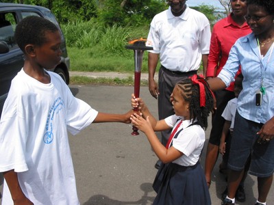 Primary school girl handed torch, Grenada