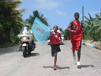 St. Lucia sprinters with flag, police escort