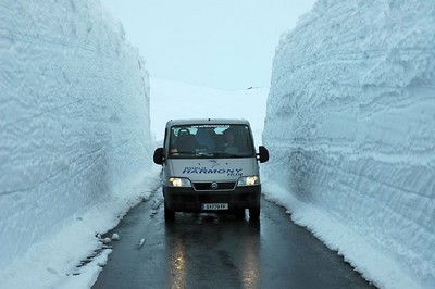 Car by snow walls