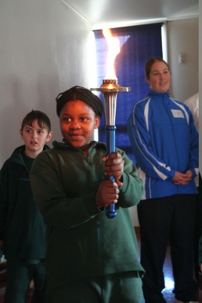 Some of the children come up to hold the torch and make a wish for world harmony.
