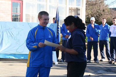 A school representative receiving the World Harmony Run certificate of appreciation.
