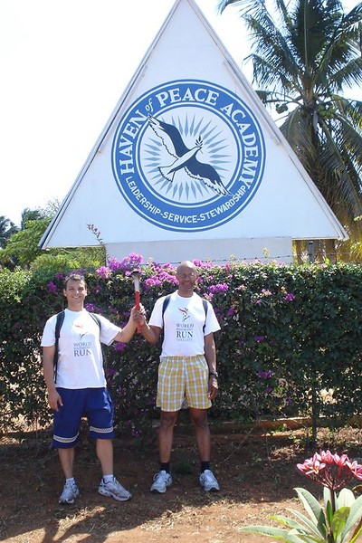 Bijon and Manatita beneath the logo of The Haven of Peace Academy HOPAC.