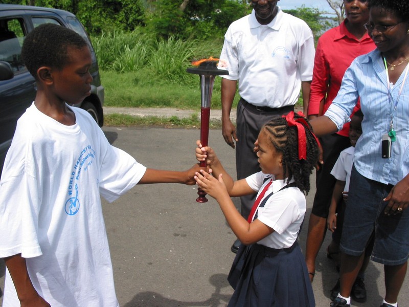 Primary school girl handed torch, Grenada