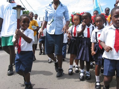 Primary school boy walks with torch, Grenada